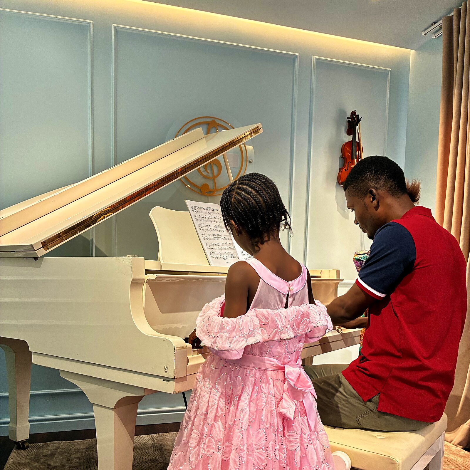A young student at the grand piano, warmly lit