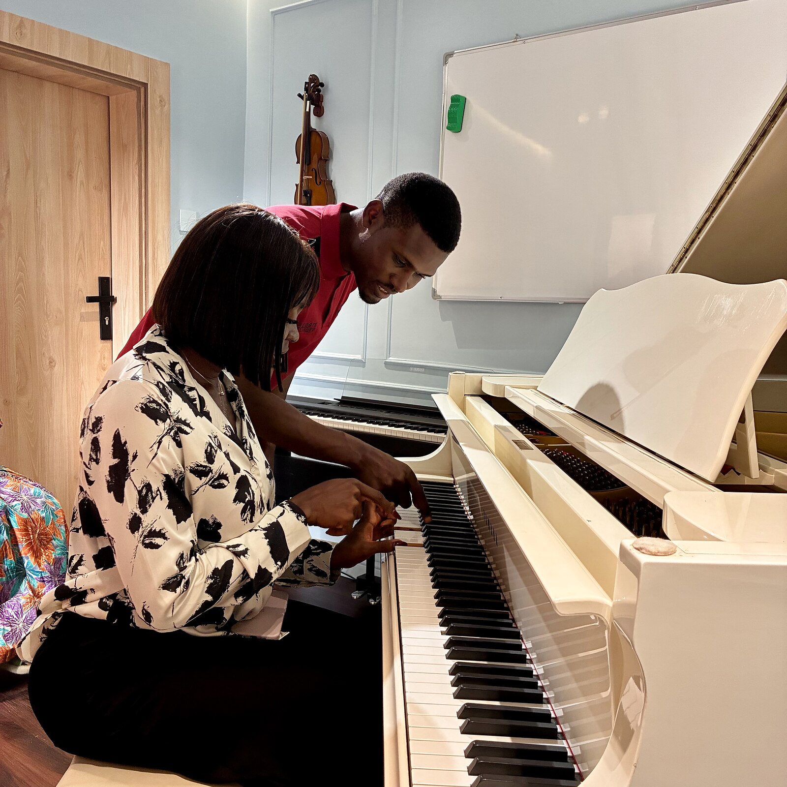 A student receiving hands-on instruction during a piano lesson